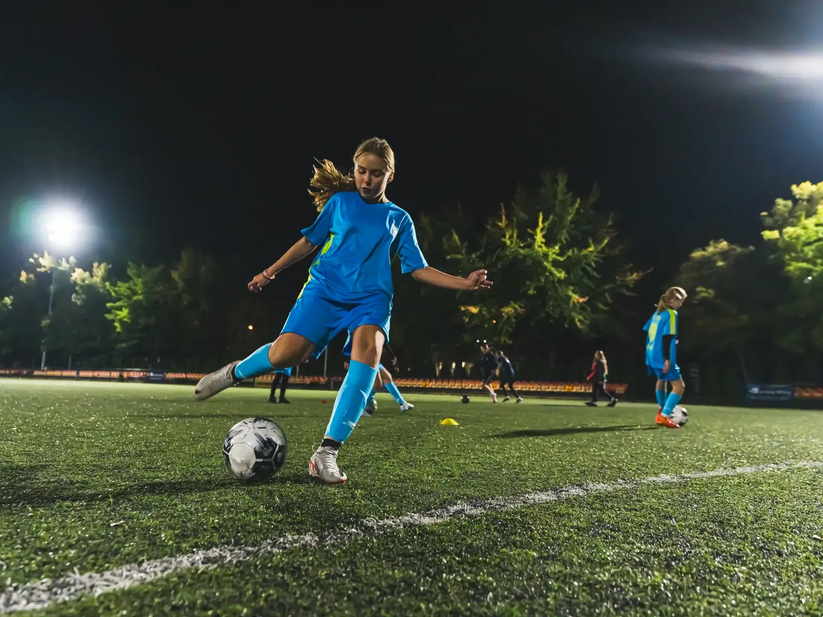 A young footballer striking a ball — ACL tears in children most often happen in sport