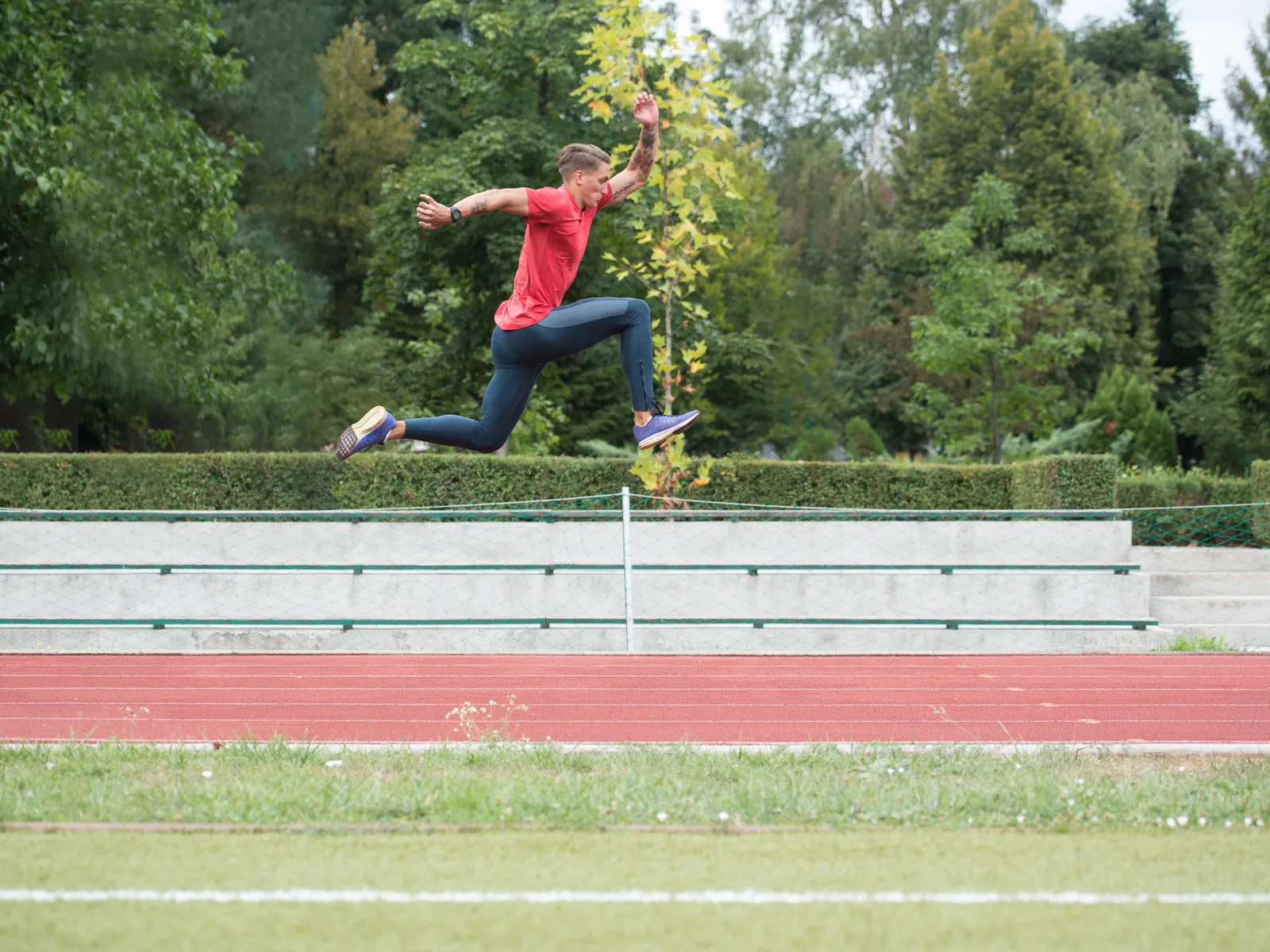 A young athlete jumping on an outdoor running track
